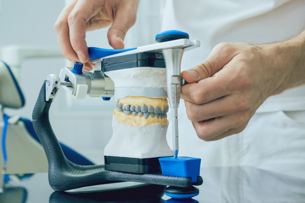 Dental technician working with articulator in dental lab